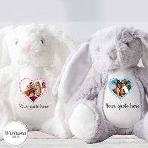 Pode incluir: Dois coelhos de pelúcia, um branco e outro cinza, cada um com uma foto em forma de coração e o texto "Your quote here". O coelho branco tem uma borda de coração rosa, enquanto o coelho cinza tem uma borda de coração azul. Os coelhos têm orelhas longas.