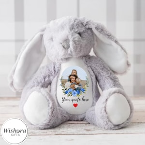Könnte beinhalten: Ein grauer Plüschhase mit einem weißen Fleck auf der Brust. Der Fleck zeigt ein Foto einer Mutter und zweier Kinder mit blauen Blumen um das Foto herum. Der Text "Your quote here" ist unter dem Foto gedruckt.