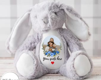 May include: A gray plush bunny with a white patch on its chest. The patch has a photo of a mother and two children with blue flowers around the photo. The text "Your quote here" is printed below the photo.