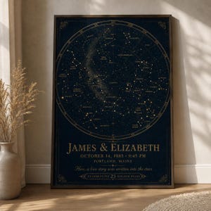 Könnte beinhalten: Ein rechteckiges gerahmtes Wandbild mit einer dunkelblauen Sternenkarte und goldenen Sternbildern. Unter der Karte steht der Text: JAMES & ELIZABETH, OCTOBER 14, 1985, 9:45 PM, PORTLAND, MAINE, Here, a love story was written into the stars.
