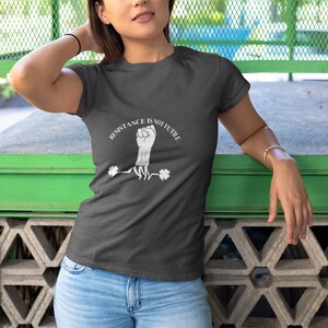 May include: A dark grey t-shirt with a white graphic of a fist with roots and the text "Resistance is not futile".