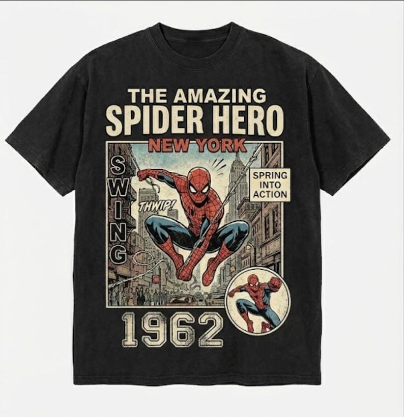 Pode incluir: Camiseta preta com um gr&aacute;fico de banda desenhada vintage do Homem-Aranha a balan&ccedil;ar-se em Nova Iorque. O design inclui o texto "The Amazing Spider Hero New York" e "1962". A camisa tem um aspeto envelhecido.