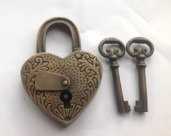Candado antiguo de latón macizo con forma de corazón tallado y dos llaves esqueleto. Diseño único.