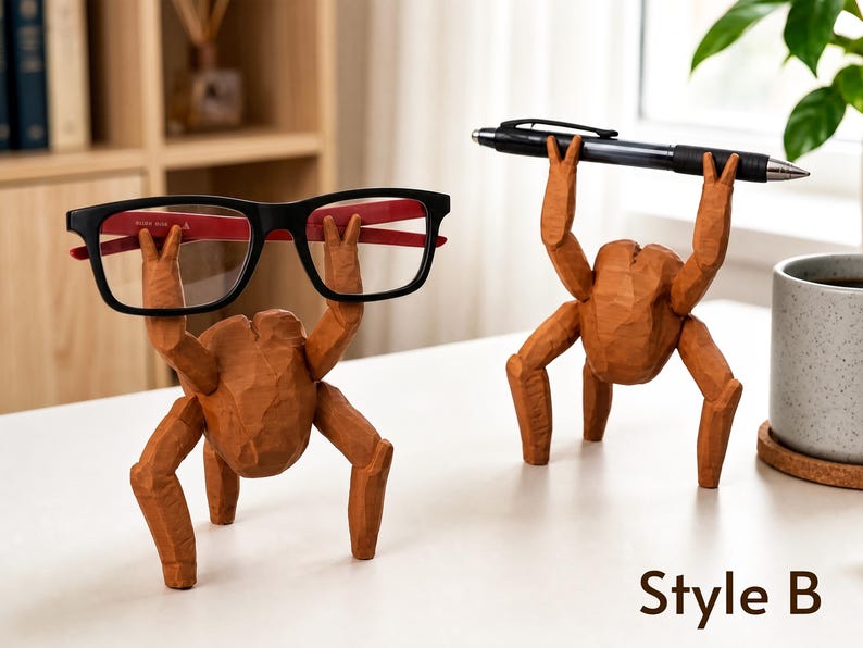 May include: Two brown, carved wooden figures shaped like multi-legged creatures. One figure holds a pair of black-framed eyeglasses with red inner temples, while the other holds a black ballpoint pen. The text Style B is visible at the bottom.