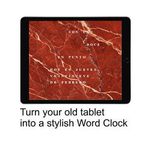 Puede incluir: Una tableta negra muestra un fondo rojo con aspecto de mármol con vetas blancas. El texto en español dice: "Son las doce en punto. Hoy es jueves, veintinueve de febrero." El texto de abajo dice: "Turn your old tablet into a stylish Word Clock."