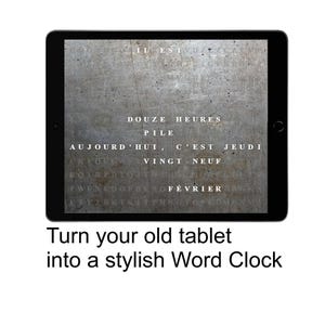 Puede incluir: Una tableta negra muestra un reloj de palabras con texto en francés sobre un fondo gris texturizado. El texto incluye frases como "Douze Heures" y "Aujourd'hui, c'est Jeudi." Debajo de la tableta, el texto dice: "Convierte tu vieja tableta en un elegante reloj de palabras."