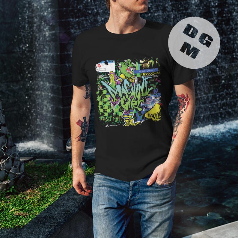 May include: A black t-shirt with a colorful graphic print of a cartoon character and the text "MACHINE GIRL".