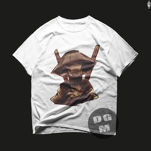 Könnte beinhalten: Weißes T-Shirt mit einem Aufdruck eines Charakters, der einen großen, braunen, kegelförmigen Hut und einen Kapuzenumhang trägt.