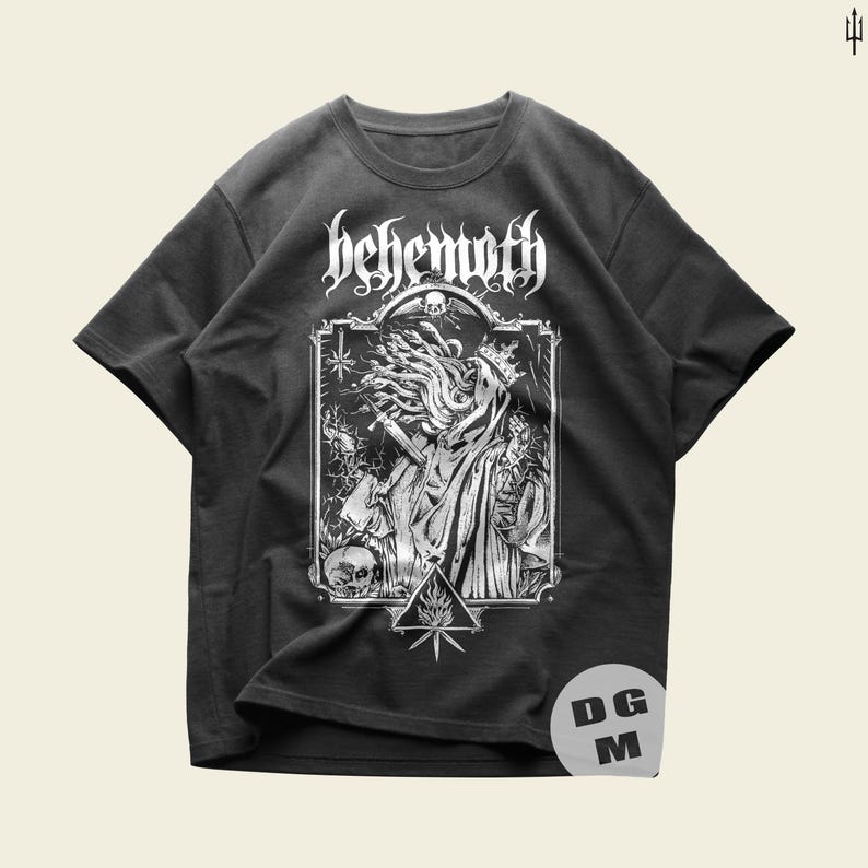 May include: Black t-shirt with a white graphic print of a figure with long hair and a crown, surrounded by skulls and a pentagram. The text "Behemoth" is printed above the figure.
