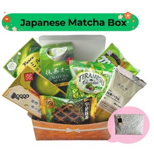 Op de afbeelding: Een Japanse Matcha Box gevuld met diverse matcha-snacks en -lekkernijen. De box bevat matcha au lait, tiramisu chocolade, matcha Baumkuchen en andere verpakte producten. De box is gemaakt van geweven hout en heeft een witte container.
