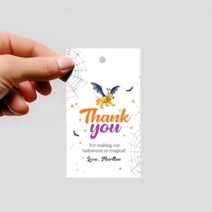 May include: A white Halloween-themed gift tag with a cartoon dog wearing bat wings, the words "Thank you" in orange and purple, and spiderwebs. The tag also includes the text "For making our halloween so magical!" and "Love, Marllen."