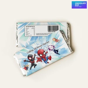 Peut inclure: Deux barres de chocolat avec des graphismes de super-héros. L'une est partiellement déballée, révélant le papier d'aluminium argenté. Les emballages présentent des personnages de Spider-Man et le texte "Calling All Sweet Heroes". Le coin supérieur droit de l'image contient le texte "CHOCOLATE BAR".