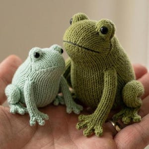 May include: A white ceramic mug with a black handle and the text "But First, Coffee" in a black, handwritten-style font. The mug is on a white surface.