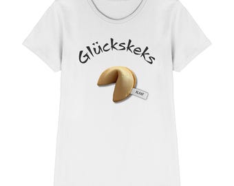 May include: White t-shirt featuring the text "Glückskeks" above a fortune cookie graphic. The fortune cookie has a small tag that reads "ALAAF". The shirt has a crew neck and short sleeves.