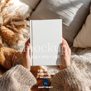 Puede incluir: Un libro blanco con la palabra "mockup" y "jpg + png + psd" impresos en la portada. El libro está sostenido por una persona que lleva un suéter beige. La imagen también incluye el texto "STEP-BY-STEP INSTRUCTIONS INCLUDED" y "SMART OBJECT".