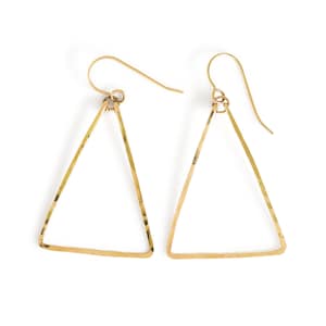 May include: A pair of gold triangle earrings with a hammered finish.