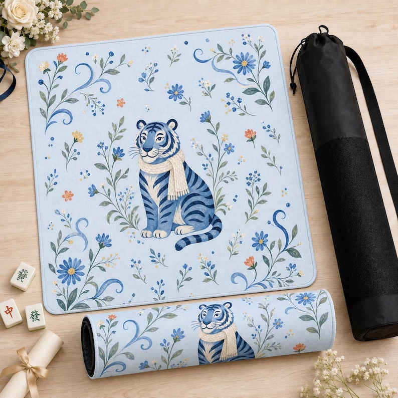 Puede incluir: Una esterilla de yoga azul claro y una esterilla rectangular a juego con un tigre azul con bufanda, rodeado de dise&ntilde;os florales. Tambi&eacute;n hay una funda de transporte negra para esterilla de yoga. Las esterillas presentan una ilustraci&oacute;n caprichosa.