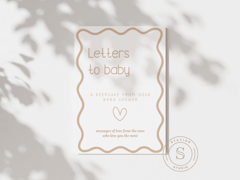 Może przedstawiać: Prostokątny znak z falistą obw&oacute;dką i napisem "Letters to baby". Znak zawiera tekst "A keepsake from your baby shower", grafikę serca oraz słowa "messages of love from the ones who love you the most."