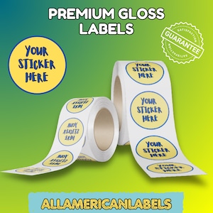 Puede incluir: Dos rollos de etiquetas redondas y brillantes blancas con un diseño azul y amarillo que dice "YOUR STICKER HERE". La imagen también incluye el texto "PREMIUM GLOSS LABELS", "GUARANTEE" y "ALLAMERICANLABELS."