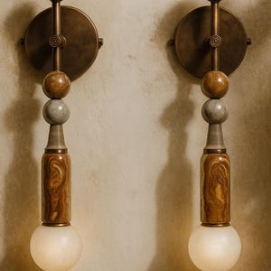 May include: Two wall sconces with a vintage design. Each sconce features a circular brass backplate, a series of stone spheres, and a wooden, cylindrical base. The sconces have a warm, inviting glow from the spherical light bulbs.