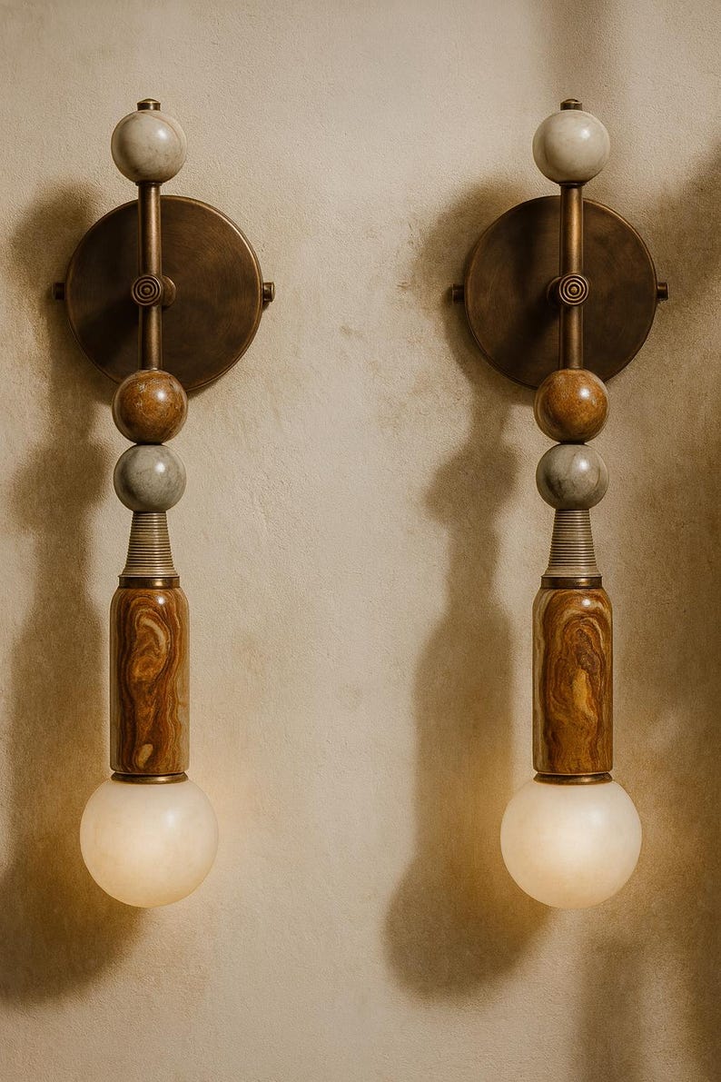 May include: Two wall sconces with a vintage design. Each sconce features a circular brass backplate, a series of stone spheres, and a wooden, cylindrical base. The sconces have a warm, inviting glow from the spherical light bulbs.