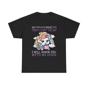 May include: Black t-shirt featuring a cartoon unicorn with a rainbow, clouds, and text that reads "BACK THE FUCK UP SPRINKLE TITS TODAY IS NOT THE DAY I WILL SHANK YOU WITH MY HORN."