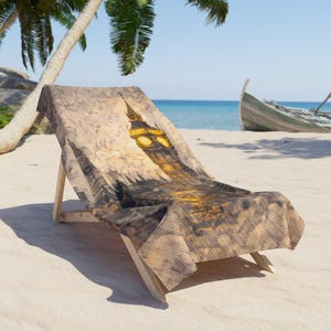 May include: A beach chair with a Big Ben design. The chair is made of light-colored wood and has a fabric cover featuring a sepia-toned image of the iconic clock tower. The scene is set on a sandy beach with a boat and palm trees.