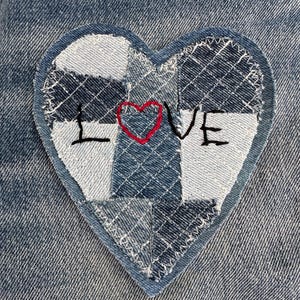 May include: A denim heart-shaped patch with the word "LOVE" stitched in black. The heart is made of various denim fabric pieces in shades of blue and white, with a red heart replacing the "O". The patch is sewn onto a denim background.