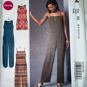 May include: McCall's sewing pattern M7394 for jumpsuits. The pattern includes options for a petite size. The cover features a woman wearing a brown jumpsuit. The pattern also shows three other jumpsuit designs in red, blue, and patterned fabrics.