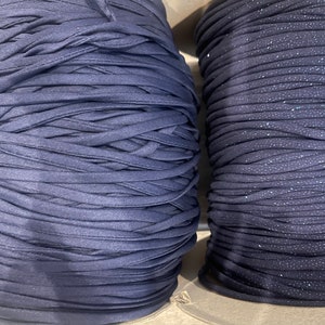 May include: Two spools of navy blue yarn. One spool has a subtle glitter finish.