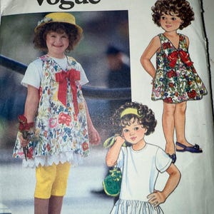 May include: A vintage sewing pattern titled "Little Vogue" featuring illustrations of children's clothing. The pattern includes drawings of dresses, tops, and leggings. The main image shows a girl wearing a floral dress with a red bow, yellow leggings, and a yellow hat.