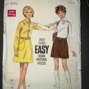 May include: Vintage Butterick sewing pattern, size 23 waist, featuring illustrations of two women in 1960s-style outfits. The pattern includes a yellow skirt suit and a brown skirt with a white turtleneck. The text reads "ONLY THREE EASY MAIN PATTERN PIECES."