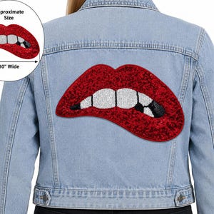 May include: A light blue denim jacket featuring a large, red sequined lip-shaped patch on the back. The patch depicts red lips with white teeth and a black accent on one tooth. An inset shows the patch is 10 inches wide at its approximate size.