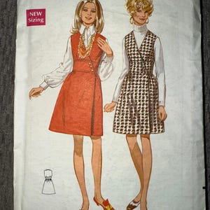 May include: Vintage Butterick sewing pattern featuring two dress designs. The pattern includes sizing information: size 8, bust 31 1/2 inches. The illustration shows a red dress and a houndstooth print dress. The pattern also includes the text "NEW Sizing".