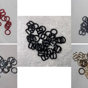 May include: A collection of various metal hardware pieces, including rings, rectangular loops, and sliders. The hardware is in several colors: red, black, silver, and gold. These findings are likely used in sewing, crafting, or jewelry making.