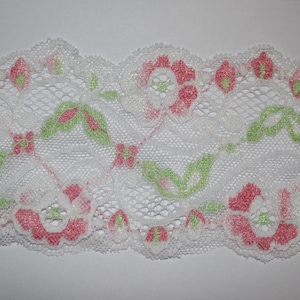 May include: White lace trim with a pink and green floral pattern.