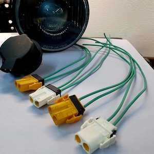 May include: Four electrical connectors with yellow and white housings and green wires. The connectors have two prongs each.