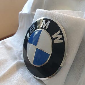 May include: A silver and black BMW logo with a blue and white propeller design.