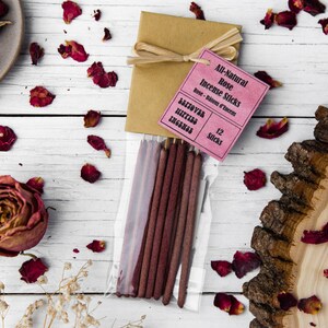 Peut inclure: Un paquet de 12 b&acirc;tonnets d'encens &agrave; la rose enti&egrave;rement naturels. Les b&acirc;tonnets sont de couleur bordeaux fonc&eacute; et sont emball&eacute;s dans un sac en plastique transparent avec un emballage en papier brun attach&eacute; avec de la ficelle. L'emballage est &eacute;tiquet&eacute; "All-Natural Rose Incense Sticks" et "12 Sticks".