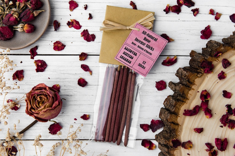 Peut inclure: Un paquet de 12 b&acirc;tonnets d'encens &agrave; la rose enti&egrave;rement naturels. Les b&acirc;tonnets sont de couleur bordeaux fonc&eacute; et sont emball&eacute;s dans un sac en plastique transparent avec un emballage en papier brun attach&eacute; avec de la ficelle. L'emballage est &eacute;tiquet&eacute; "All-Natural Rose Incense Sticks" et "12 Sticks".