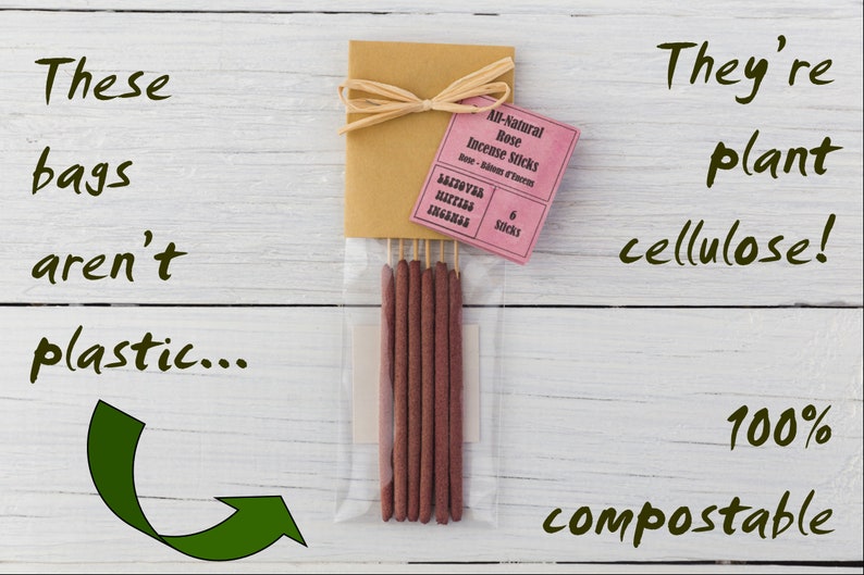 Peut inclure: Un paquet de six b&acirc;tonnets d'encens &agrave; la rose enti&egrave;rement naturels dans un sac en plastique transparent. Le sac est attach&eacute; avec un ruban brun et une &eacute;tiquette rose qui indique "All-Natural Rose Incense Sticks". Le texte "They're plant cellulose! 100% compostable" est &eacute;crit sur un fond en bois blanc.