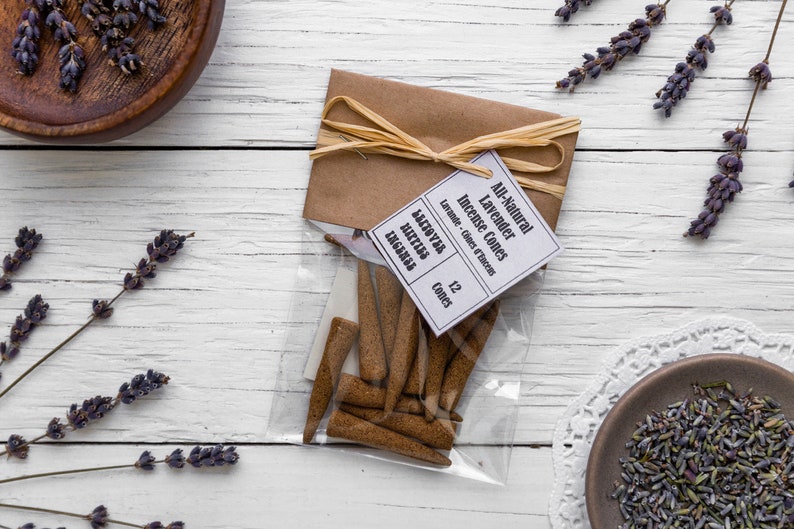 Op de afbeelding: Een pakket van 12 volledig natuurlijke lavendel wierookkegels, gebonden met touw en een label met de tekst "All-Natural Lavender Incense Cones -  Lavender - Cones et Encens - 12 Cones".