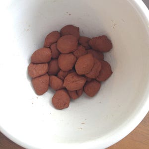 Measured and portioned incense dough balls, clustered together inside a mixing bowl, ready to be formed into sticks or cones.