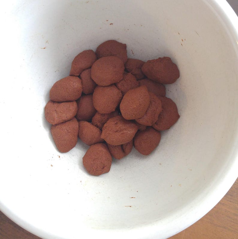 Measured and portioned incense dough balls, clustered together inside a mixing bowl, ready to be formed into sticks or cones.