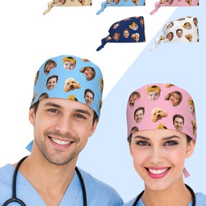 May include: A collection of scrub caps featuring a repeating pattern of human faces and a dog face. The caps are available in various solid background colours including light blue, pink, white, navy blue, and tan, each with tie-back closures.