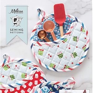 May include: Sewing pattern for four styles of pot holders and a matching dish towel. The pot holders are in various colors and patterns, including red, blue, white, and green. The dish towel is white with a red and green Christmas tree design. The text "POTHOLDER PARADE" is printed in blue on a white background.