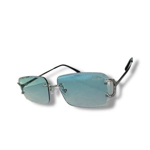 May include: Silver frame sunglasses with blue tinted lenses. The sunglasses have a square shape and a thin metal frame.