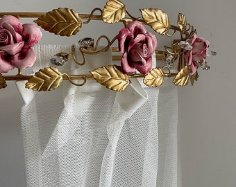 May include: A gold metal canopy with pink ceramic roses and crystal accents. The canopy is attached to a white sheer curtain.