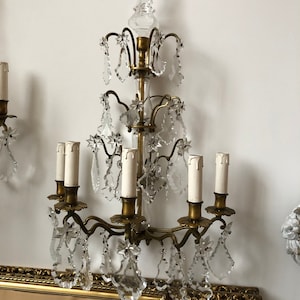 Peut inclure: Une applique murale dor&eacute;e avec un design de lustre en cristal. L'applique a six bougeoirs et est orn&eacute;e de gouttes de cristal.