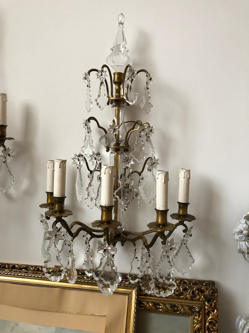 Peut inclure: Une applique murale dor&eacute;e avec un design de lustre en cristal. L'applique a six bougeoirs et est orn&eacute;e de gouttes de cristal.